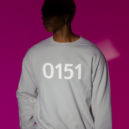  Person wearing a light grey sweatshirt with bold white “0151” print, standing against a vibrant magenta background.